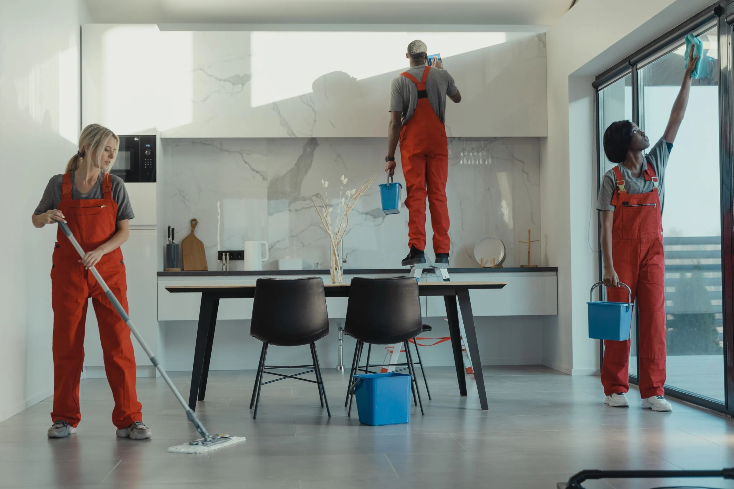 Rengøringsassistenter gør rent i et moderne kontor og frokostrum